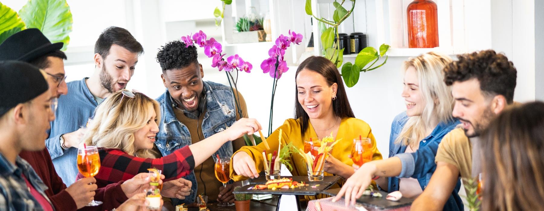 a group of people eating and drinking around a counter